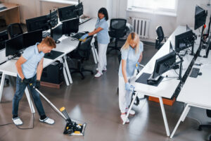 Tres trabajadores limpiando una oficina